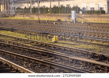A detailed perspective of multiple active train tracks with gravel and green grass, highlighting crucial transportation infrastructure, urban planning, and continuous journey progress