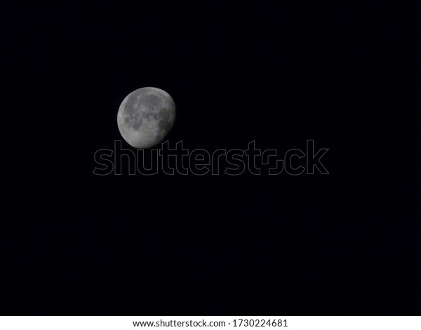 A\
detailed photo of an almost full moon at\
night.