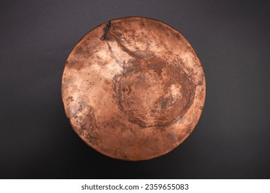 Detailed photo of round, textured copper object surface.