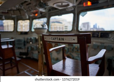 Detailed Picture On The Captain Wooden Chair With Writing Captain On Bridge Of Historic Warship Who Served In Royal British Navy During World War Two And Now Is Exhibited Like Museum Ship In London.