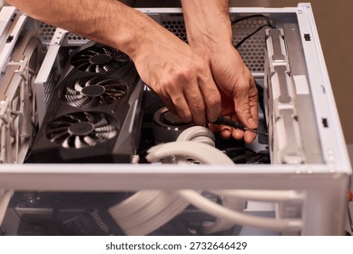 Detailed process of securing and positioning computer fans inside chassis. Carefully assembling and securing case fans within computer case under focused workshop lighting