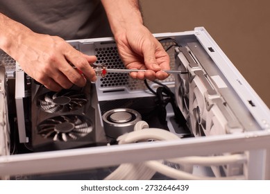 Detailed process of securing and positioning computer fans inside chassis. Carefully assembling and securing case fans within computer case under focused workshop lighting