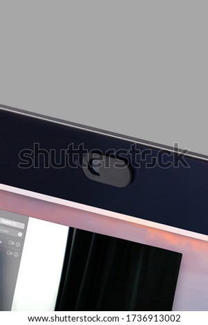Detailed shot of a black webcam cover fixed on a laptop camera. The anti-spy slider made for your privacy and security is in open position. 