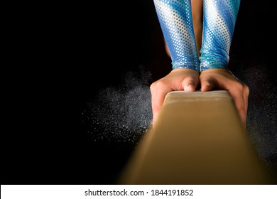 Detailed shot of female gymnast balancing on balance beam with chalk dust on black background. - Shutterstock ID 1844191852