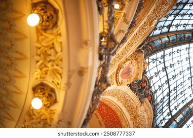 A detailed shot of the ornate ceiling inside a Parisian opera house, showcasing the lavish gold accents and artistic murals that define its historic charm. - Powered by Shutterstock