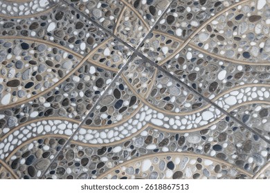 Detailed tile pattern featuring smooth, varied pebbles in gray, white, and black hues. Wavy lines create a natural, organic design. Seamless texture. 