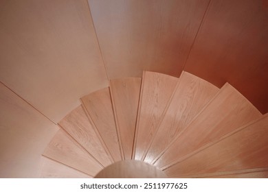  A detailed top-down view of a wooden spiral staircase showcasing smooth, natural wood grain and elegant design. - Powered by Shutterstock