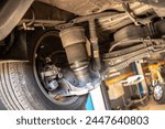 Detailed view of air suspension repair with bellows in car workshop, showcasing expertise.