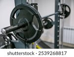 A detailed view of a barbell rack holding weight plates in a gym.