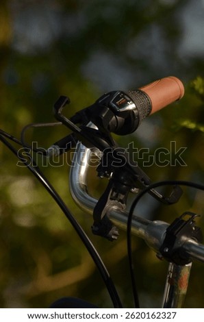 A detailed view of bicycle handlebars featuring a brown grip, Shimano RevoShift 7-speed gear shifter, and brake levers.