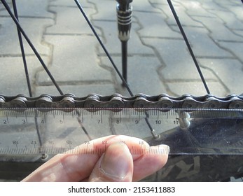 Detailed view of bike chain segments length being measured to check its state of wear and tear.
