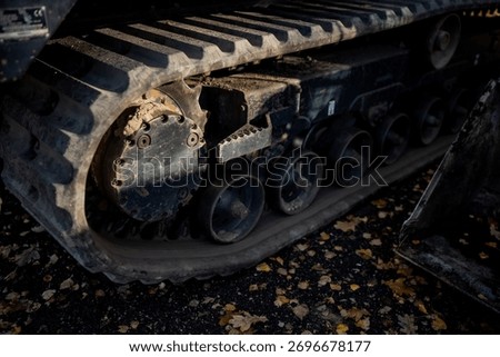 Detailed view of compact loader rubber track undercarriage with drive sprocket and support rollers showing terrain traction and engineering structure of tracked machinery