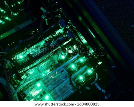A detailed view of a computer server rack illuminated by green LED lights, showcasing cables and hardware in a modern data center environment.