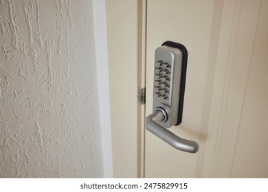 A detailed view of a contemporary door featuring a digital keypad lock for enhanced security indoors