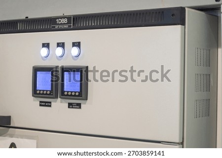 A detailed view of a control panel featuring digital displays, buttons, and indicator lights, commonly used in industrial and electrical systems for monitoring and control functions.