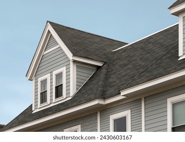 Detailed view of a gable-style dormer window on a sloped roof of a newly built family house in Brighton, MA, USA - Powered by Shutterstock