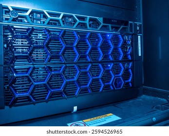 Detailed view of a high-tech server rack showcasing blue LED lights and a unique hexagonal pattern, emphasizing modern technology and data management.