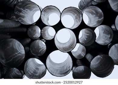 A detailed view of industrial metal pipes arranged in a circular pattern, creating a tunnel effect - Powered by Shutterstock