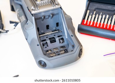 Detailed view of internal components of a remote control unit with tools arranged nearby