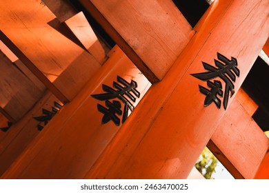 Detailed view of japanese callygraphy in a red temple in Japan (Fushimi Inari-taisha). Translated text: Serve, Serve, Serve - Powered by Shutterstock