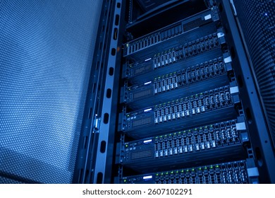 A detailed view of a modern data center server rack showcasing rows of servers illuminated by blue lighting, highlighting advanced technology and efficient data processing systems.