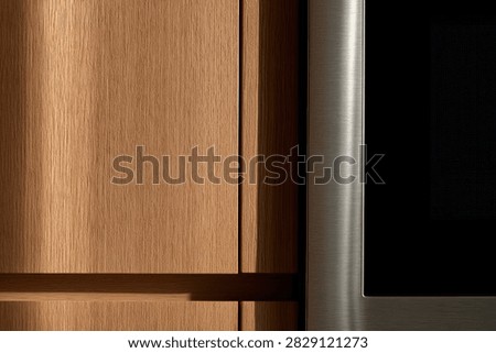 A detailed view of a modern kitchen, showcasing the texture of wooden cabinets alongside a sleek stainless steel appliance.