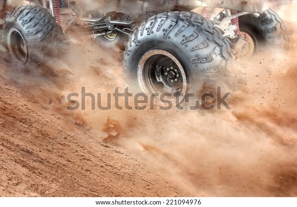 Detailed view of motion the wheels tires and\
off-road truck shaft that goes in the dust of the desert  through\
the wheels on the sand