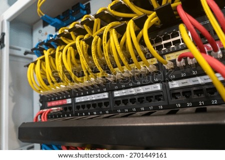 A detailed view of a network switch featuring colorful Ethernet cables connected to various ports, representing modern technology and data communication infrastructure.