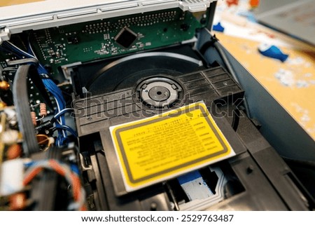 A detailed view of an open internal CD drive inside a device, revealing the circuit board, wiring, and disc mechanism components