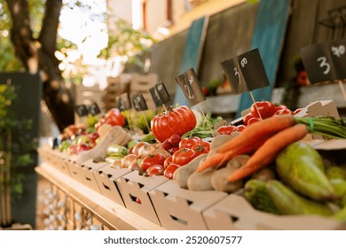 Detailed view of organic agricultural fresh produce in cardboard boxes placed on greenmarket stands with price tags. Closeup of locally grown colorful fruits and vegetables at farmers market booth. - Powered by Shutterstock