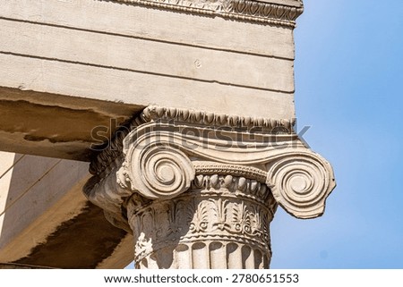 Detailed view of an ornate Ionic column capital with characteristic volutes and egg-and-dart carvings at the Erechtheion temple, Acropolis of Athens.