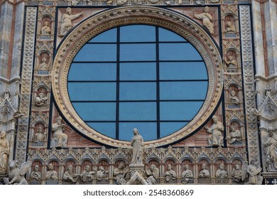 Detailed view of an ornate rose window surrounded by intricate religious sculptures and decorative elements on a historic cathedral facade. A masterpiece of Gothic architecture. - Powered by Shutterstock