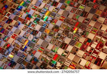 Detailed view of patterned silicon semiconductor wafer showing many integrated circuit dies in a geometric grid, colorful electronic texture for chip manufacturing and technology themes.