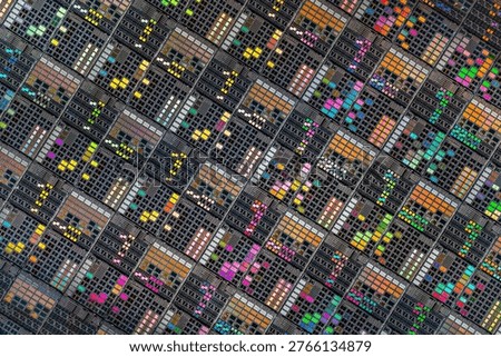 Detailed view of patterned silicon semiconductor wafer showing many integrated circuit dies in a geometric grid, colorful electronic texture for chip manufacturing and technology themes.