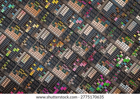 Detailed view of patterned silicon semiconductor wafer showing many integrated circuit dies in a geometric grid, colorful electronic texture for chip manufacturing and technology themes.