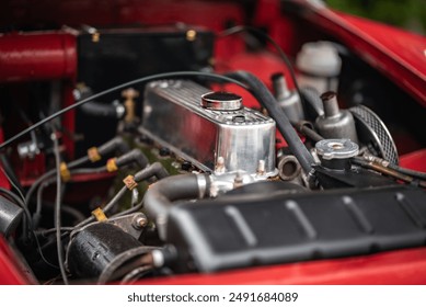 Detailed view of red cars engine with intricate design and engineering, featuring components like heatshrink tubing. Keywords motor vehicle, car, auto part, hood, kit car, more - Powered by Shutterstock