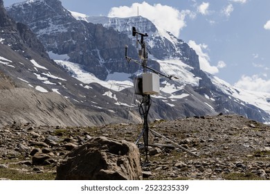 A detailed view of a weather monitoring station set against a backdrop of towering, snow-capped mountains, perfect for environmental data collection and scientific research photography. - Powered by Shutterstock