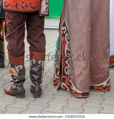 Details of the Bashkir traditional national clothing. Men's leather boots with applications and the bottom of women's dresses with the same pattern. National holiday of Tatars and Bashkirs Sabantuy