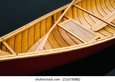 Details Of A Beautiful Wooden Canoe Boat On The Water. Paddles And Seat Of A Boat Floating On Dark Water, No People