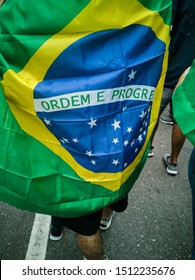 Details of the Brazilian Flag, wrinkled or decorated, used by the population in popular and twisted soccer movements, worn as clothing, cape, or carried in the wind through the streets.