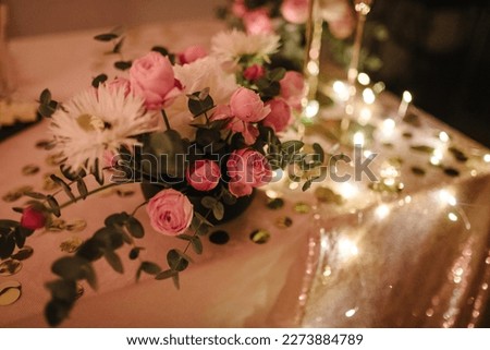 Details candlelight date in a restaurant. Setting, date for two, Valentine's Day evening, burning candles. Bouquet of flowers and decor on table. Romantic dinner at home at night. Side view. Closeup.