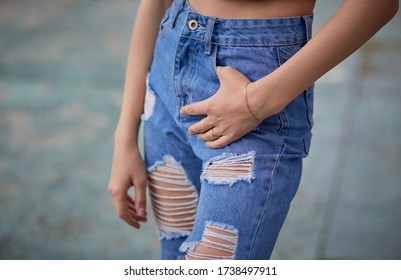 Details of clothes young woman. Pretty young girl in a casual clothes.Woman in ragged jeans. Hand in the pocket.Selective focus