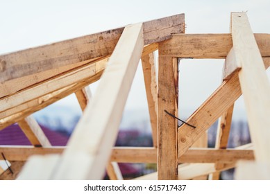 Details of construction site, timber structure of truss roof system. The wooden structure of the building