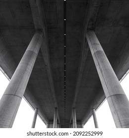 Details Of A Dridge Built In Reinforced Concrete Seen From Below. Concrete Architecture Details, Floor And Stronge Support Columns.  Minimal Modern Geometric Shape And Forms. Under A Highway Bridge