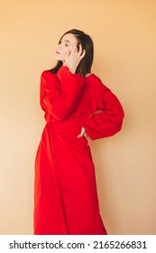 Details of everyday elegant look. Model wearing casual outfit. Red color long dress featuring long puff sleeves with cuffs in trendy minimalistic style. Lantern sleeves and dress. Girl fix hair.