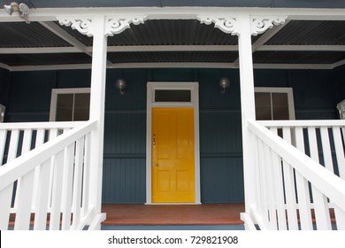 Details of a freshly painted colonial Queensland home with a welcoming sunshine yellow front door.