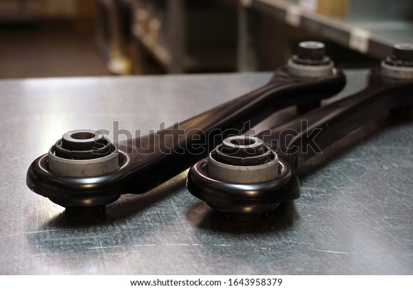 Details of a front or\
rear suspension of a modern car. Control arm. New original quality\
spare parts . Trade in original quality spare parts. Service and\
repair concept.