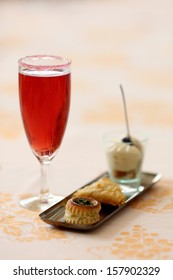 Details of a glass of kir royal and amuse bouche.