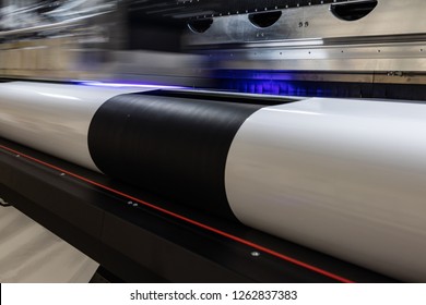 Details From The Inside Of A Large Scale Professional Printer, Print Head Passing By At Great Speed Over Vinyl Rolls During Production Hours. 