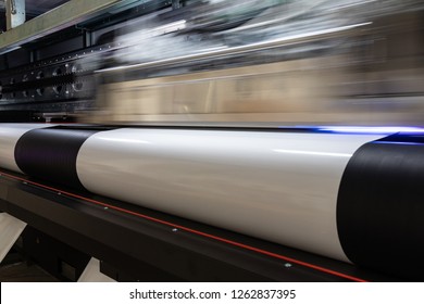 Details From The Inside Of A Large Scale Professional Printer, Print Head Passing By At Great Speed Over Vinyl Rolls During Production Hours. 